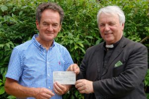 Paul presents a cheque for £1500 to Fr Steven from the Family Quiz and other fundraising events.