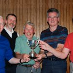 The winning team receive the trophy from organiser John Hayhurst (centre)
